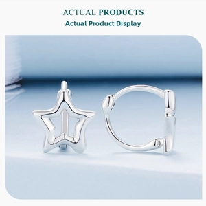 Close-up of S925 sterling silver hollow star earrings with polished finish on blue base