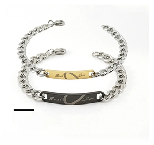 Macro detail of gold and black Cuban chain bracelets with Real Love engraving