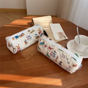 Close-up of quilted cotton pencil cases with cute rabbit and dog prints on wood desk