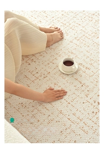 Detail of cream-colored waterproof carpet with brown textured dots and soft fabric texture