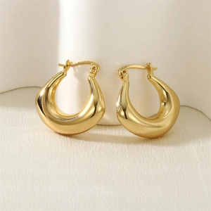 Detail view of gold chunky U-shaped hoop earrings with a textured vintage metallic finish