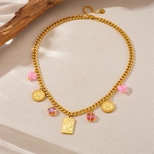 Macro view of gold Cuban chain necklace with Queen Elizabeth II portrait pendants and pink crystals