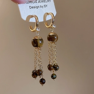 Detail view of vintage long tassel earrings with tiger eye beads and golden chains