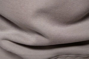 Macro shot of high-density knitted cotton fabric in taupe for premium autumn sweatshirts