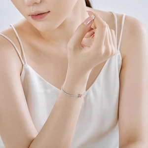 Detail of S925 sterling silver tennis bracelet with pink heart cubic zirconia on wrist