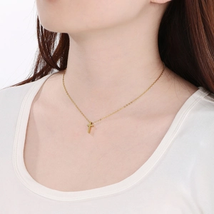 Elegant gold-tone cross pendant necklace in stainless steel shown on female model neck
