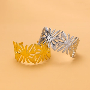 Detailed macro view of gold and silver open bracelets with hollow coral leaf patterns