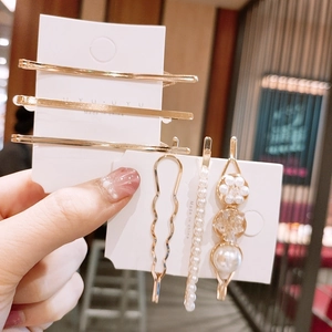 Gros plan détaillé d'un lot de 6 barrettes dorées avec des perles et des strass