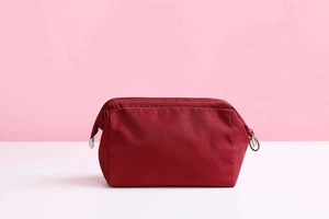 Close-up of red nylon waterproof cosmetic bag with silver metal zipper detail