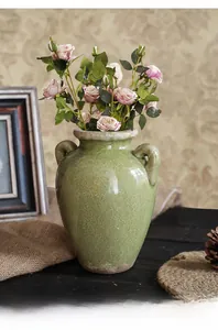 Dettaglio del vaso vintage in ceramica verde salvia con smalto craquelé e manici