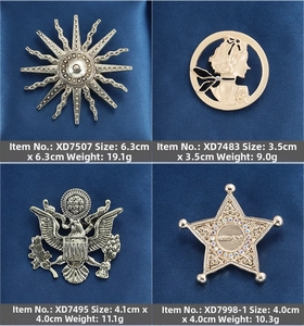 Detail view of vintage baroque brooches with embossed metal and rhinestone star patterns
