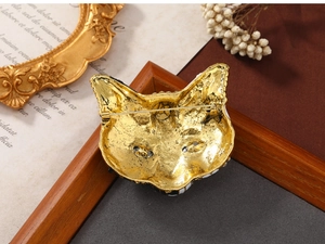 Macro detail of a vintage owl brooch featuring antique gold finish and enamel details