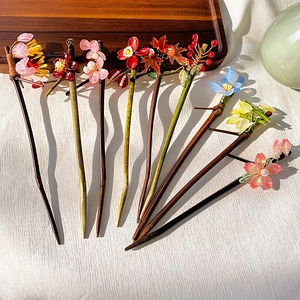 Detailed view of traditional Chinese hairpins with resin flowers and faux pearls