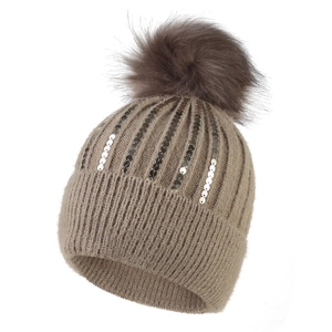 Dettaglio del cappello in maglia marrone chiaro con paillettes e pompon morbido