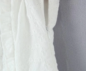 Detailansicht der weißen Stickerei und des unsichtbaren Reißverschlusses am Kleid