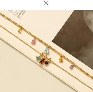 Detail of 18K gold-plated brass chain necklaces featuring colorful drop-shaped zircon stones
