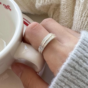 Close-up of S925 sterling silver multi-layer pleated ring worn while holding a coffee cup