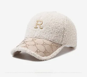 Detail view of cream sherpa baseball cap with embroidered R and rhinestone brim accents