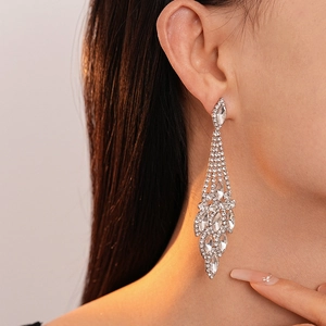 Dettaglio di orecchini a goccia scintillanti con nappe argentate e strass brillanti