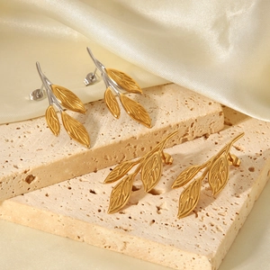 18K gold and silver stainless steel olive leaf earrings on a natural stone base