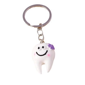 Simpatico portachiavi a forma di dente con viso sorridente su sfondo bianco puro