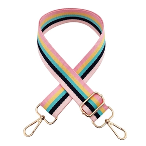 Detail of colorful striped canvas bag strap with polished gold-tone metal swivel hooks