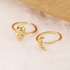 Detailed close-up of golden portrait and crescent moon rings with sparkling rhinestones