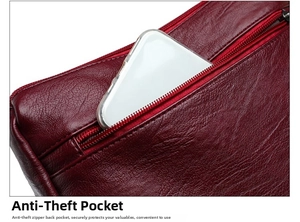 Close-up of the hidden anti-theft back zipper pocket on burgundy textured leather bag