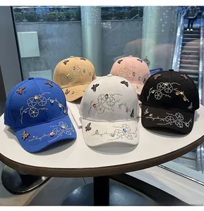 Detail shot of assorted baseball caps featuring rhinestone butterfly and floral patterns