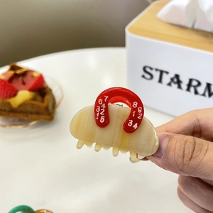 Cute handbag shaped acetate hair claw clip in beige with red handle and numeric print details