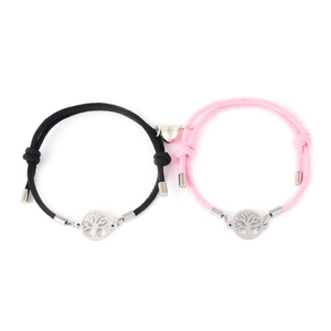 Close-up of magnetic heart clasp and tree of life charms on braided couple bracelets
