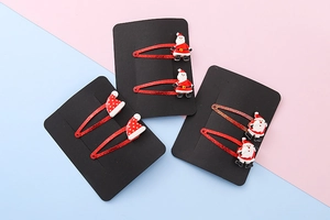 Detail of red Christmas hair clips featuring Santa Claus and resin hat decorations