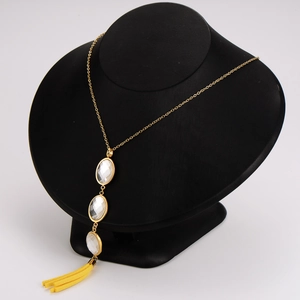 Minimalist stainless steel necklace with white stones and yellow tassels on bust stand