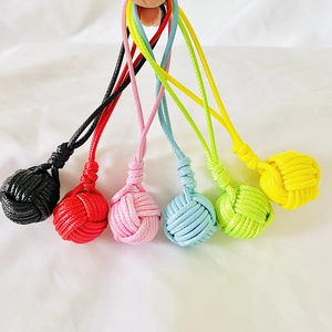 Close-up of colorful handmade monkey fist knot keychains in six vibrant woven cord styles