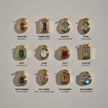 Grid view of twelve monthly birthstone charms in gold settings from January to December