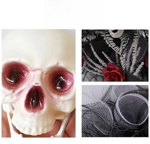 Close-up of realistic skull, red roses and black mesh ribbon on Halloween wreath decoration
