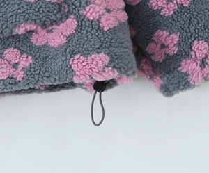 Detailed close-up of drawstring toggle on grey floral sherpa fleece pullover sweater
