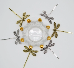 Detailed view of six vintage dragonfly hair clips in antique gold and silver finishes