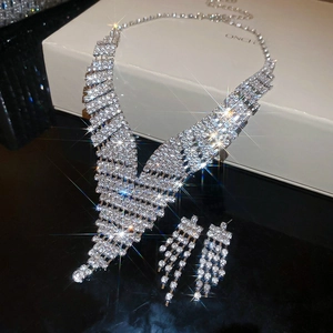 Close-up of sparkling V-shaped fringe necklace and matching tassel earrings with rhinestones