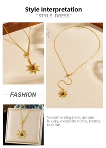 Detail of gold sun pendant necklace with tiger eye stone and snake chain on beige background