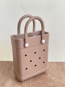 Macro detail of brown EVA beach bag showing circular perforated holes and texture
