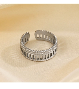 Macro shot of silver Roman geometric open ring on yellow pleated silk fabric