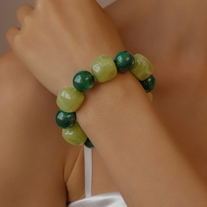 Close-up of green acrylic square and round beaded bracelet worn on a woman wrist