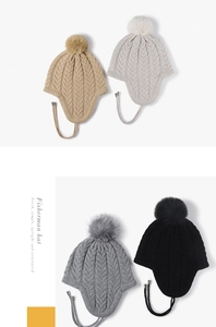 Detailed knit texture of winter beanies with pom-poms and earflaps in multiple colors