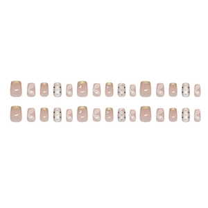 French champagne polka dot press-on nails with floral nail art and rhinestone accents