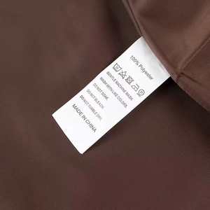 Gros plan de l'étiquette d'entretien indiquant 100% polyester et conseils de lavage