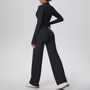 Détail de veste de sport noire avec passe-pouces et pantalon de yoga large vue dos