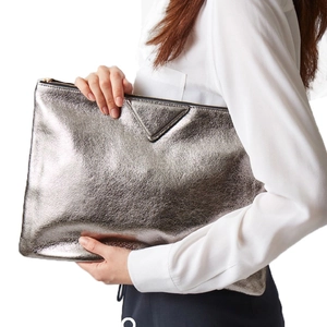 Silver metallic crackle texture clutch bag with triangle patch held by a model