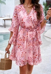 Detail of pink floral chiffon V-neck wrap dress with ruffled sleeves and waist tie