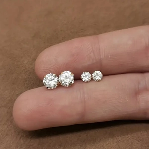 Close-up of small round zircon stud earrings in two sizes with 14K gold claw setting